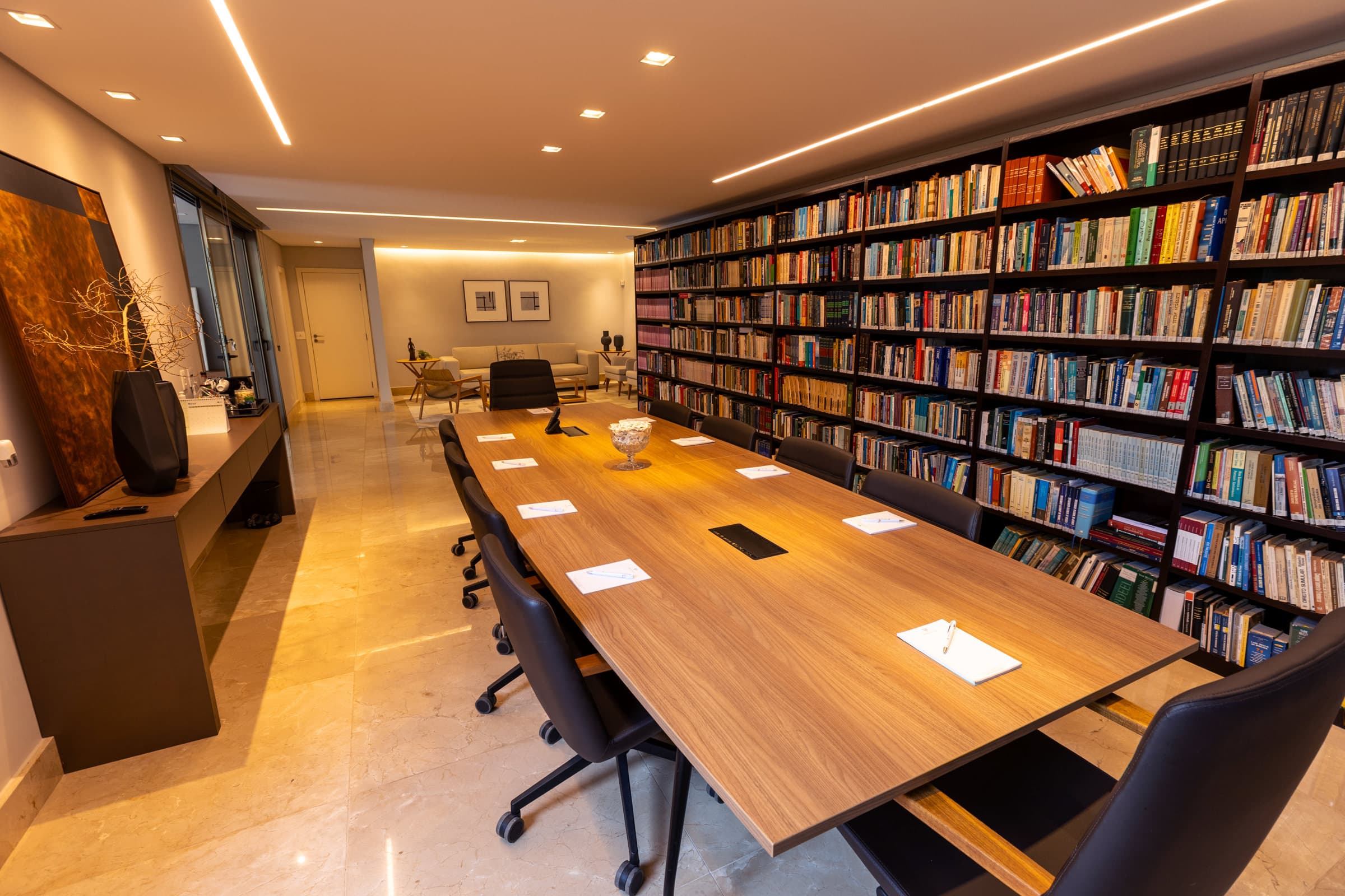 Sala de reuniões integrada à biblioteca e à área de estar